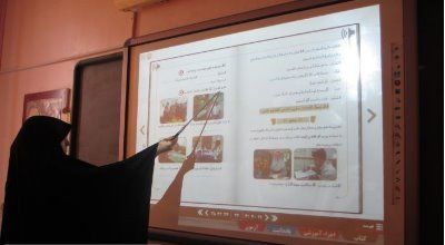 معلم یا دانش‌آموز در حال ارائه و نشان‌دادن پوستر پروژه علمی با تصاویر و نمودارها در نمایشگاه یا رویداد آموزشی مدرسه